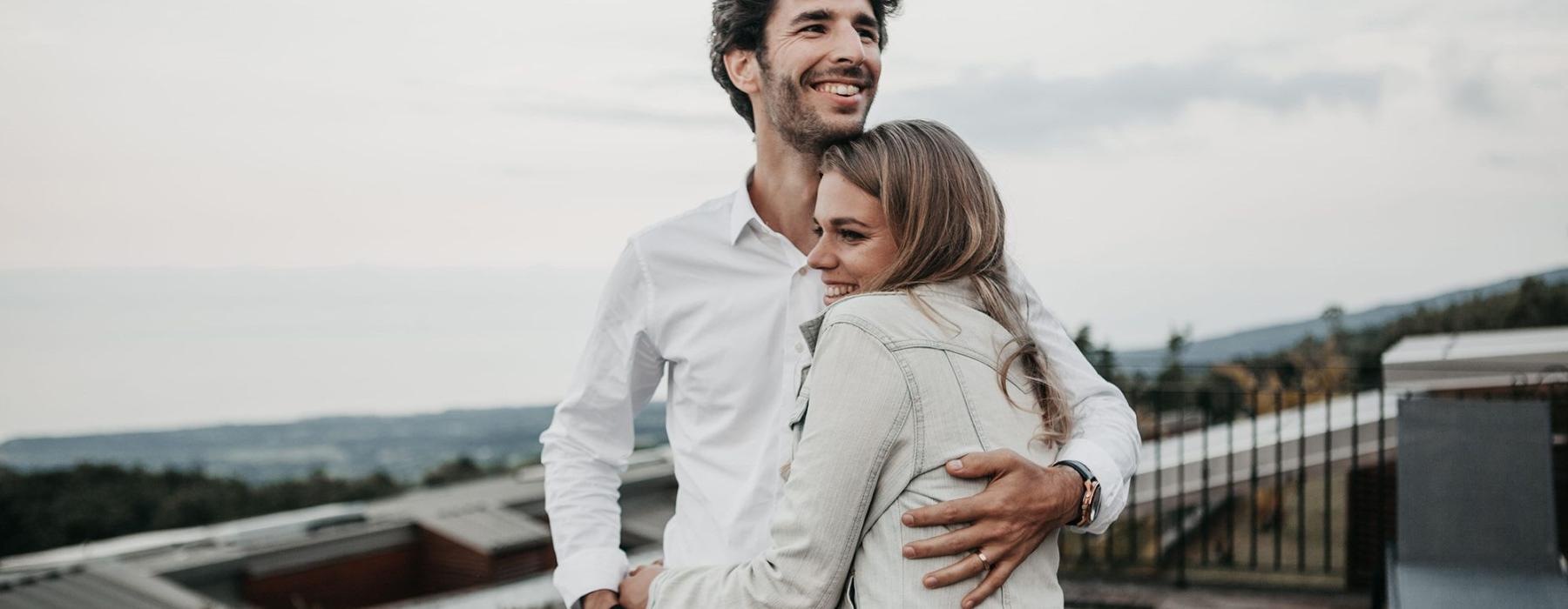 a man and woman hugging on rooftop terrace
