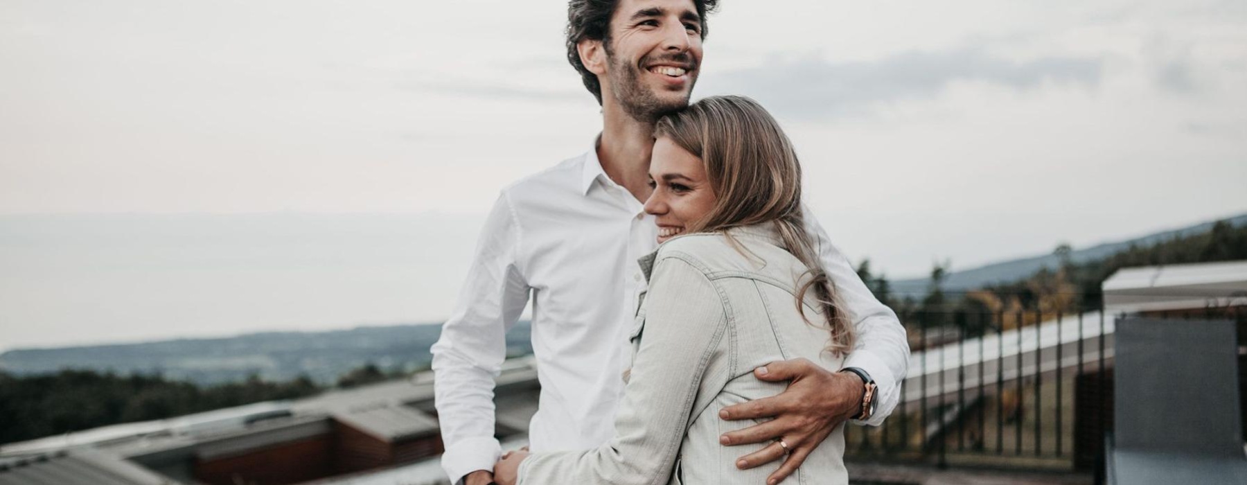 a man and woman hugging on rooftop terrace